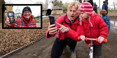 A woman gawps as she shows a little girl the Love Exploring augmented reality app on her phone. They are at Preston Park, wrapped up warm. Inset is Councillor Jim Beall holding up his phone to show a screenshot of him confronted by a CGI T-Rex.