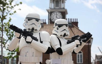 Two Star Wars stormtroopers holding blaster weapons stand side by side, ready for action. Stockton Town Hall can be seen behind them.