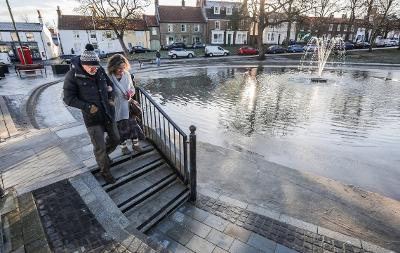 An image of a couple walking down steps towards Norton Duck Pond