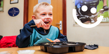 Young boy eating and smiling